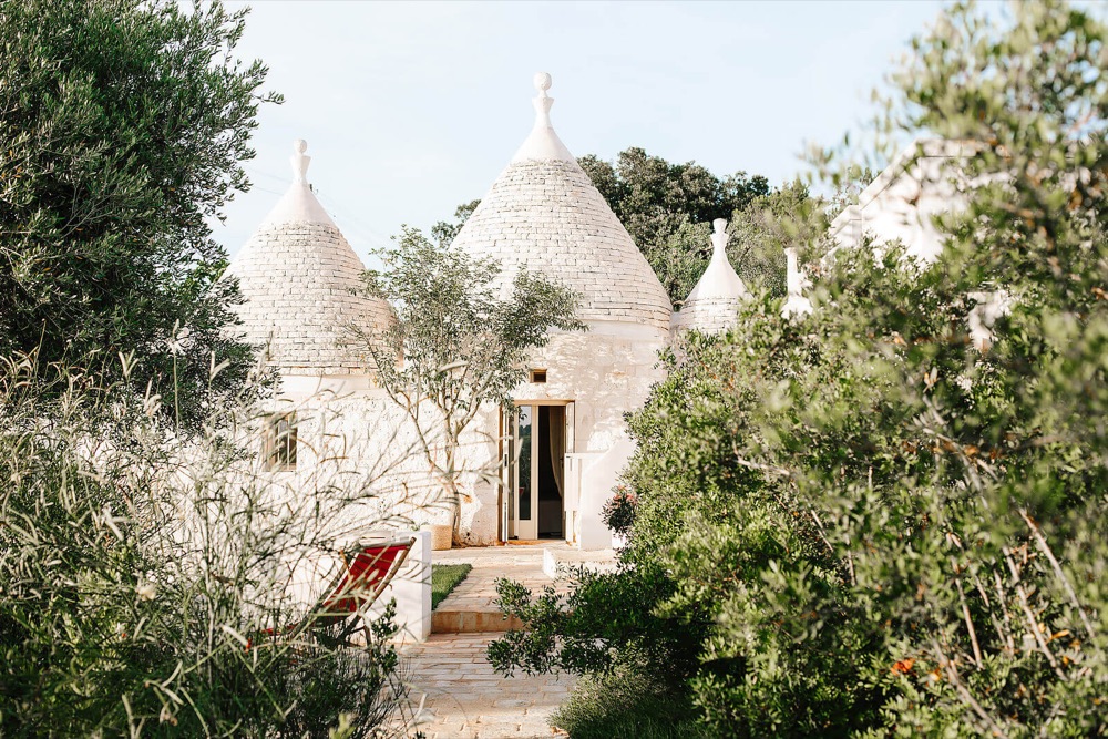 Traditional cone-roofed trulli homes among olive trees in Puglia